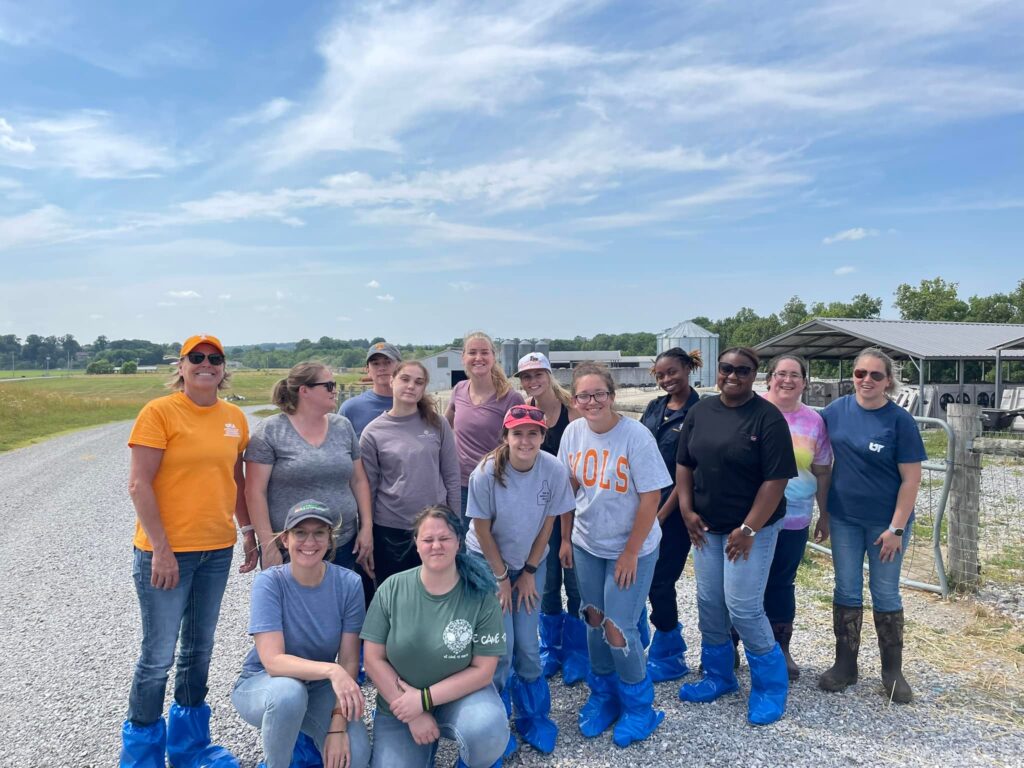 2023 Cohort posing in front of dairy farm