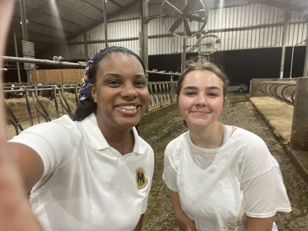 Two womein standing in dairy barn