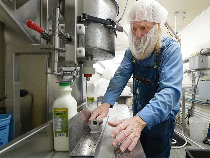 person fills a container with milk