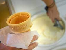 person scooping ice cream into a cone