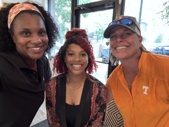 student posing with two faculty members