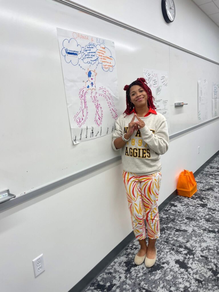 one student posing beside chalk board in classroom