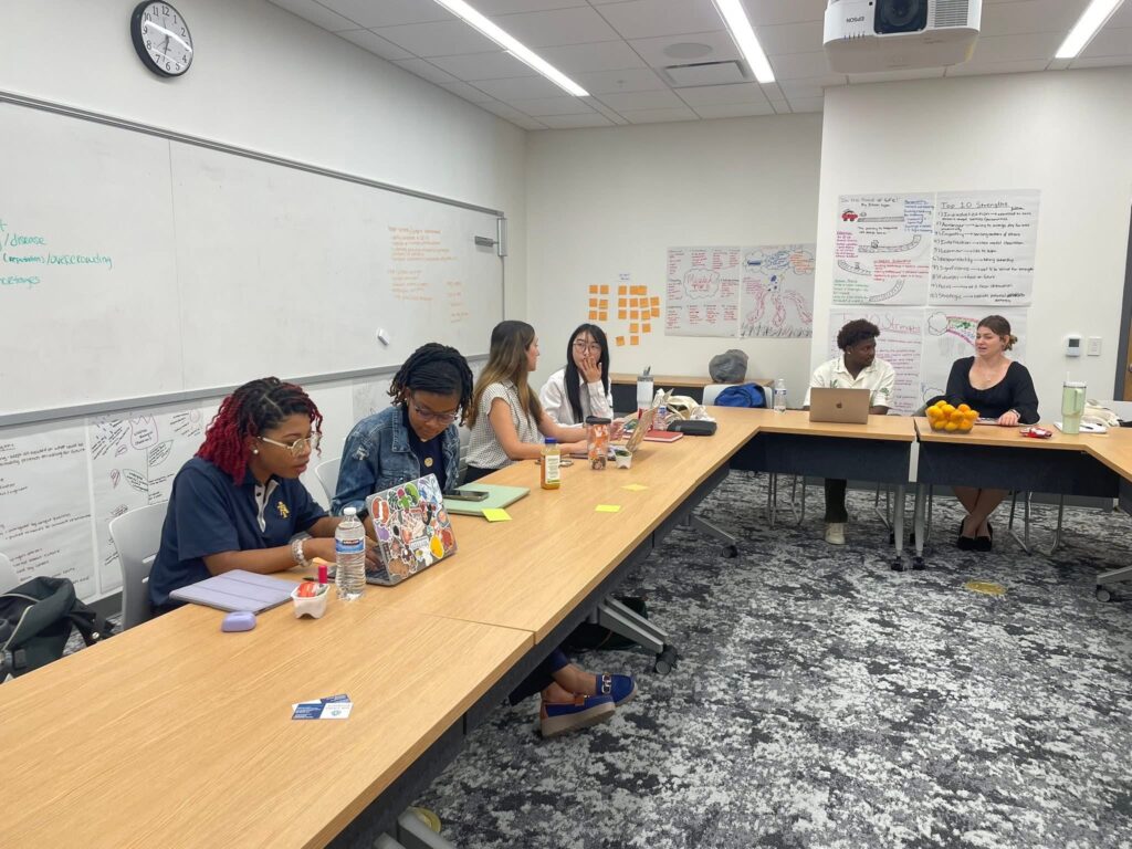 students working at long tables in a classroom