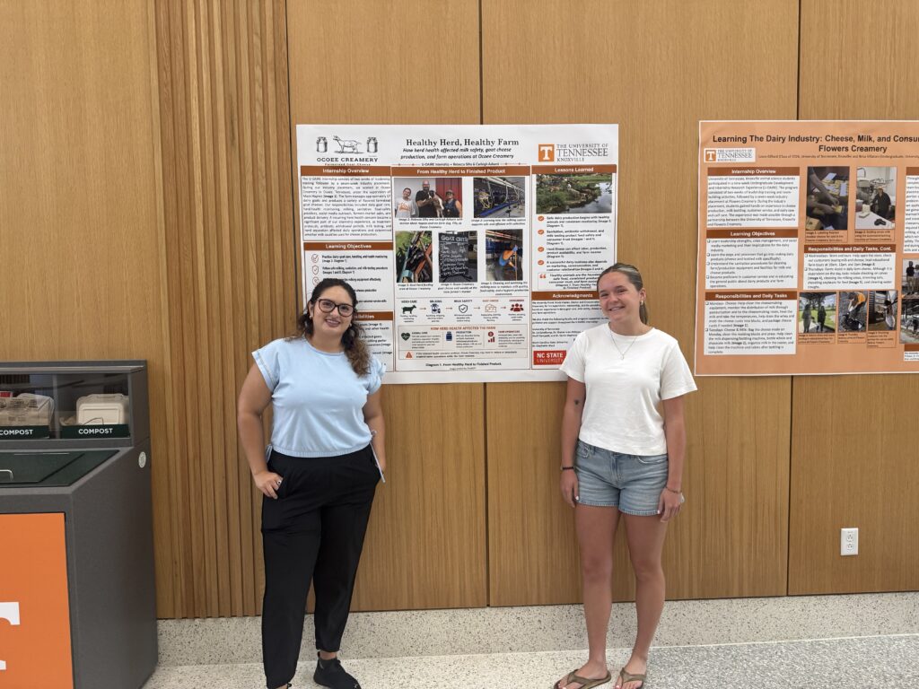 Two female students standing with their poster