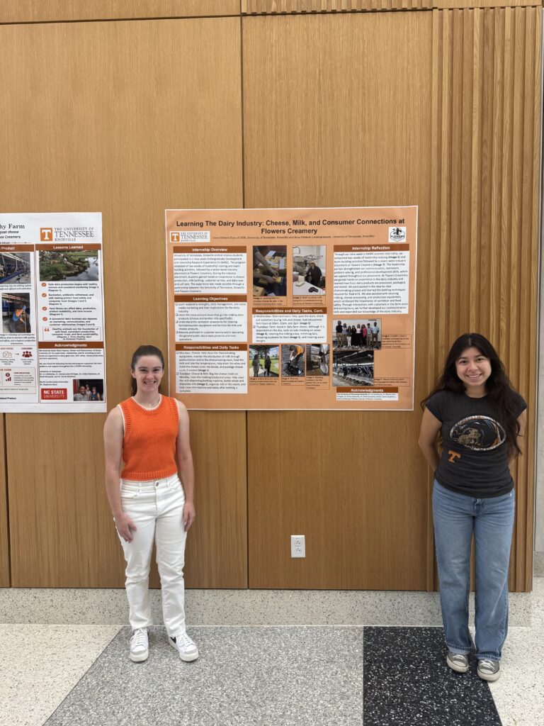 Two students standing with their poster