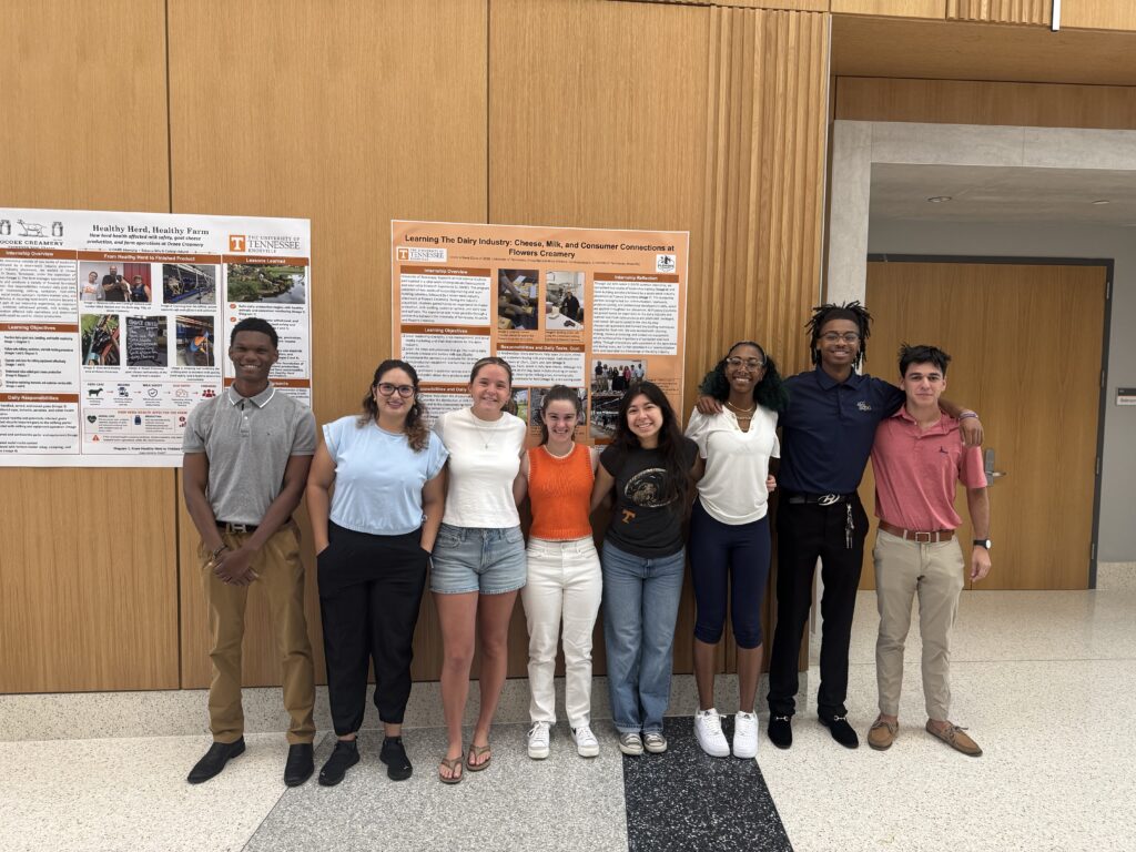 Group of students stand in front of posters